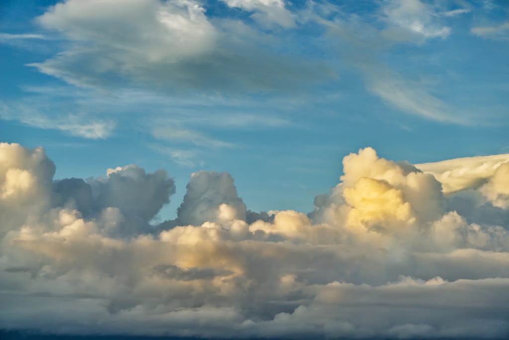 Vibrant cumulus clouds in a bright blue sky, depicting a peaceful day.